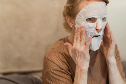 Mature woman with healthy glowing skin gently touching her face during skincare routine close-up