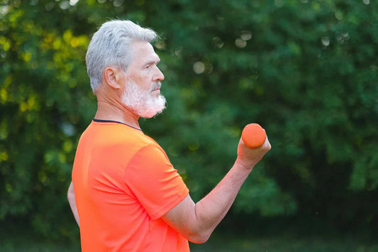 Senior adult lifting dumbbells during strength training workout to maintain muscle mass and prevent age-related decline